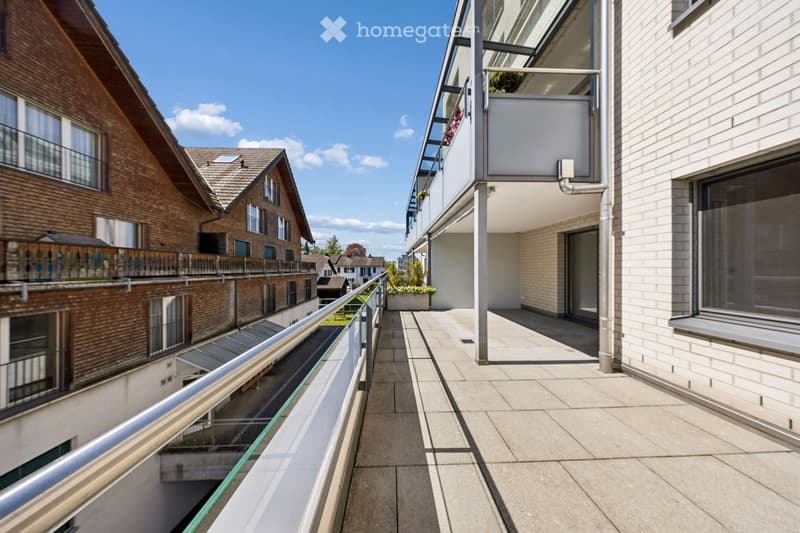Balcony / Terrace. A balcony with a metal railing and a tiled floor, overlooking a street with buildings.