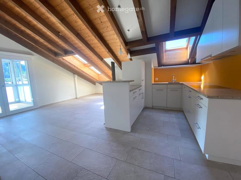 Modern kitchen with white cabinets, a central island, and a sleek sink area. The space features exposed wooden beams on the ceiling and large windows allowing natural light to fill the room.