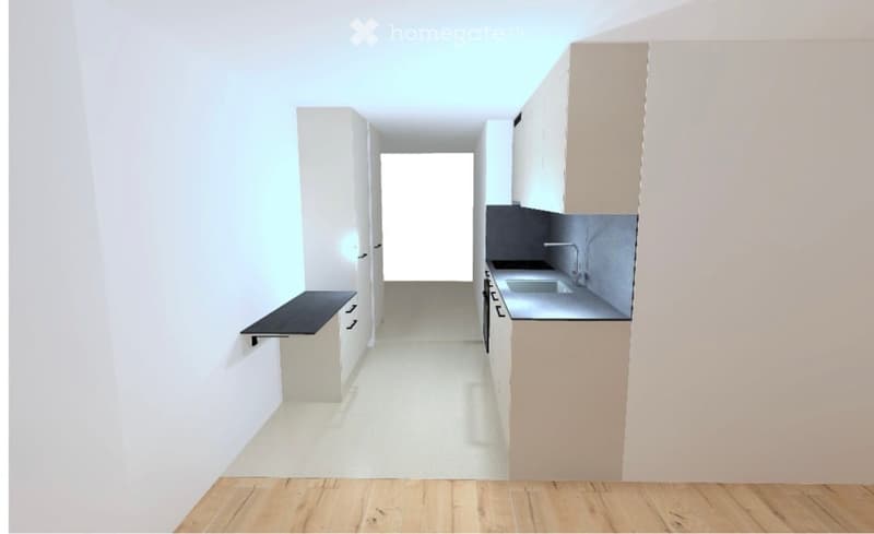Empty kitchen with white cabinets, a countertop, and a sink. The space is well-lit with natural light coming from a window at the far end.