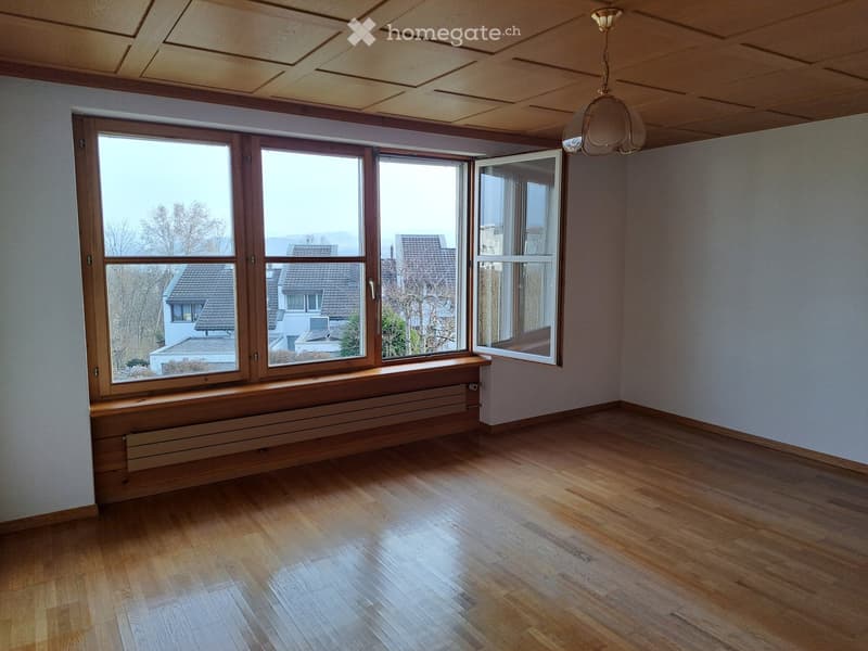 Empty room with wooden flooring, large windows, and a radiator under the windowsill.