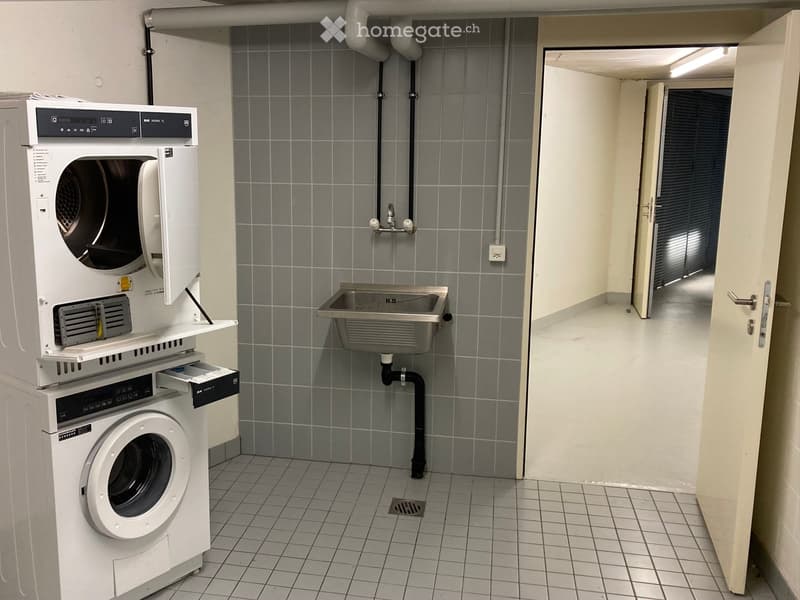 Laundry room with a washing machine, dryer, and a sink.