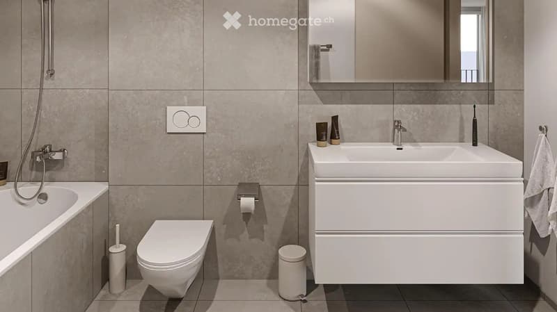 Modern bathroom with a bathtub, toilet, sink, and mirror. Includes a towel, toothbrush, and toiletries on the sink counter.