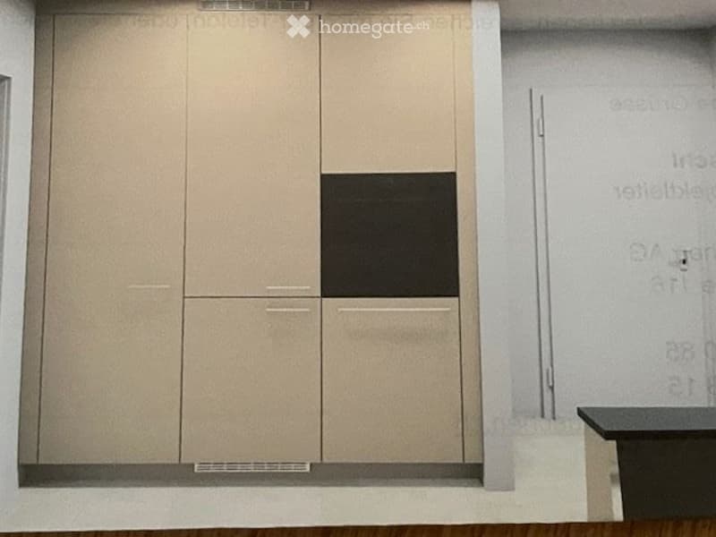 Empty room with light-colored cabinetry and a small black countertop, no furniture or equipment present.