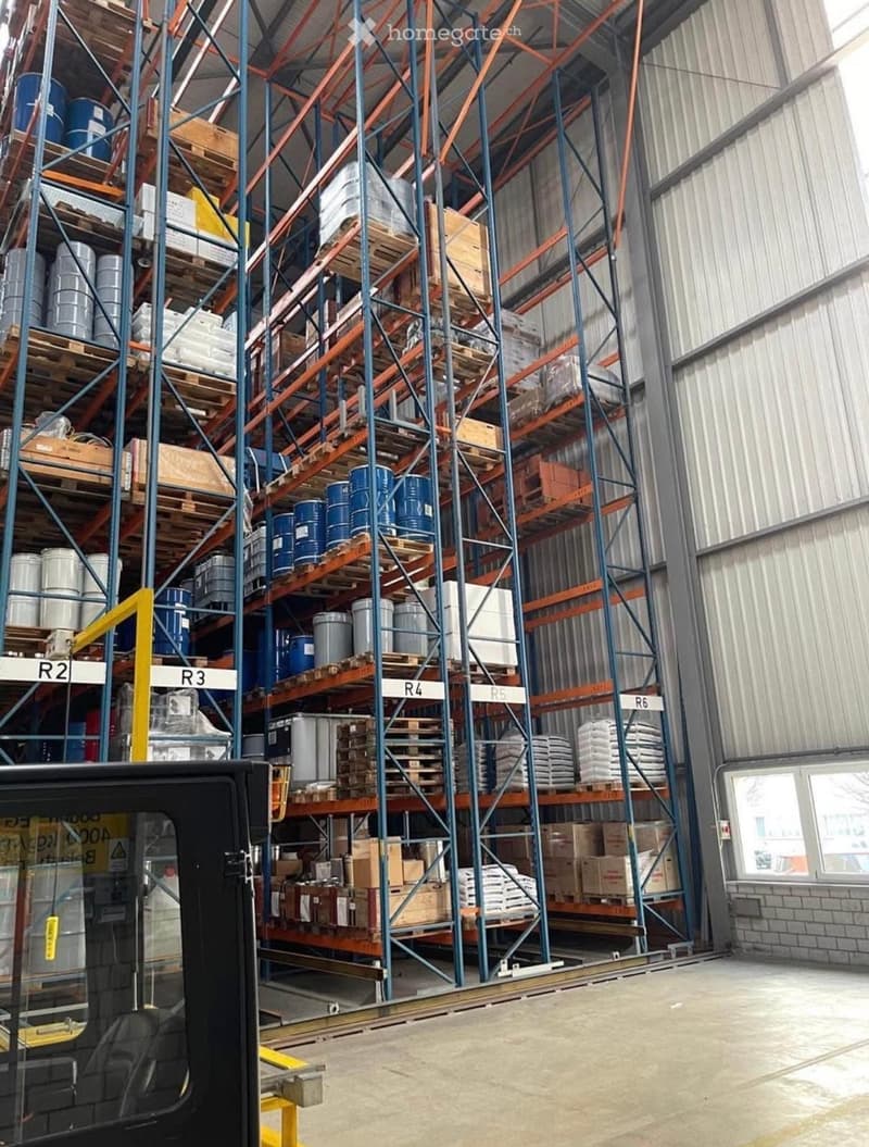 industrial storage racks, multiple rows of shelves, various goods on pallets, industrial setting