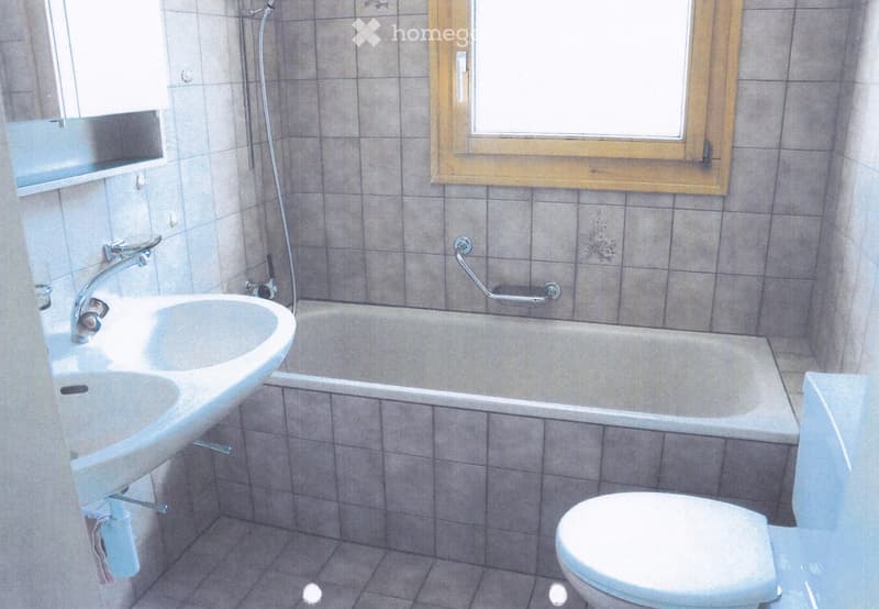 tiled bathroom with a bathtub, sink, and toilet