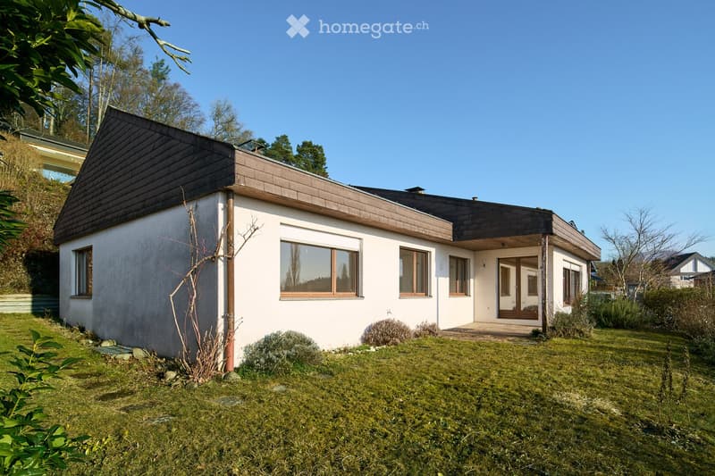 detached house, white exterior, black roof, several windows, ground level, no visible garage