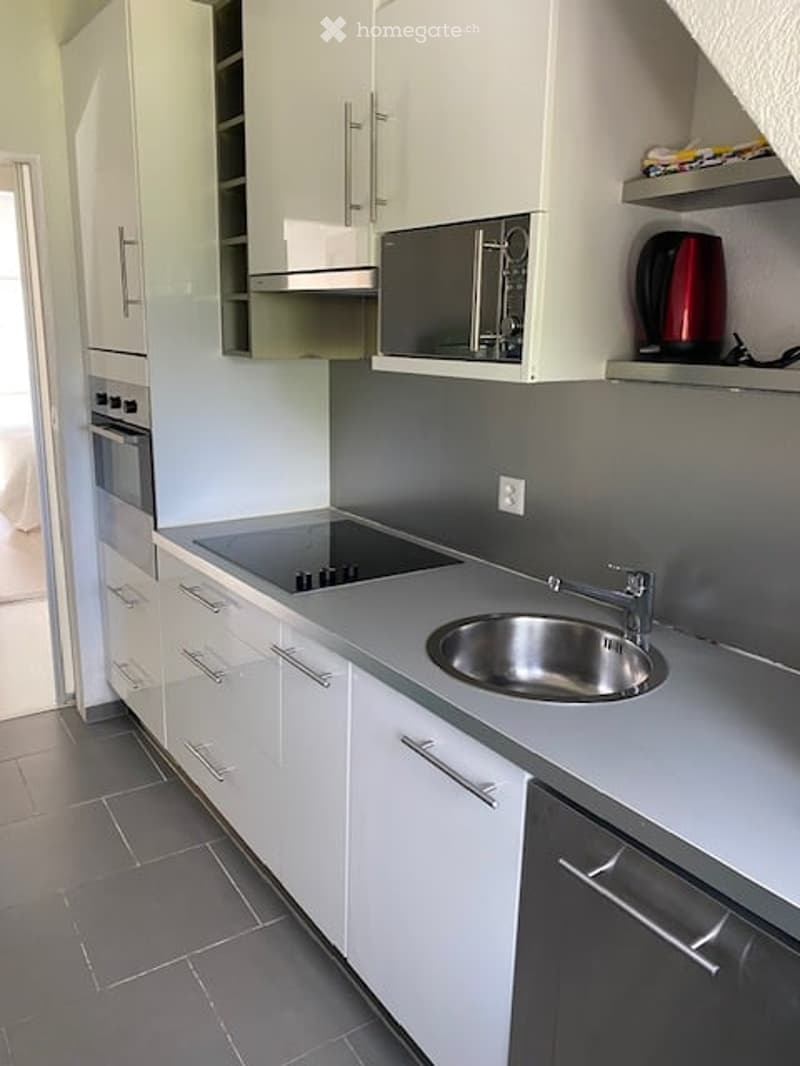 modern kitchen, tile flooring, white cabinets, stainless steel appliances, electric stove, microwave, dishwasher, grey countertops
