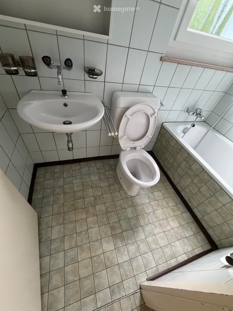 Bathroom with a sink, toilet, and bathtub, featuring tiled walls and floor.