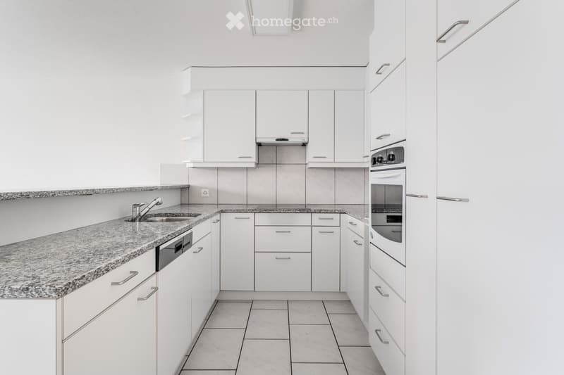 Modern kitchen with white cabinets, granite countertop, sink, faucet, oven, and dishwasher.