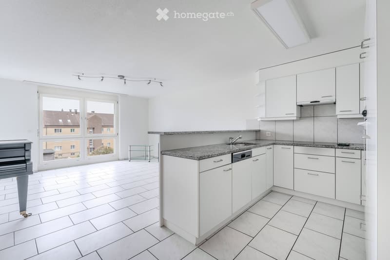 Modern kitchen with white cabinets, granite countertop, stainless steel sink, and a small glass stool near the window.