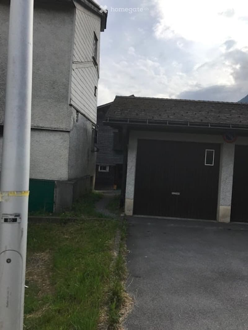 A two-story building with a garage entrance and a paved driveway.
