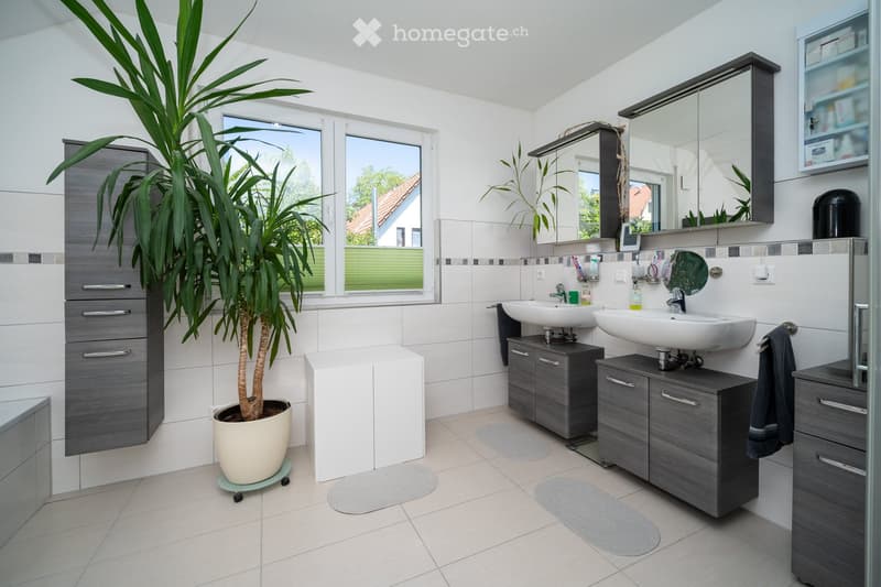 double sinks, cabinets, toilet, shower, plant, tiled floor