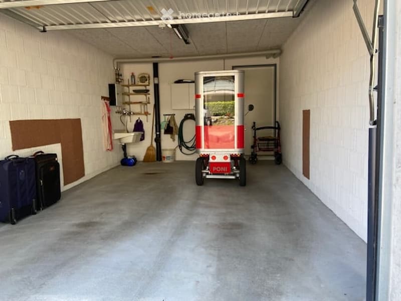 {"visible_features": ["Garage"], "type": "Garage", "objects": [], "description": "Garage with concrete floor, white brick walls, shelves, cleaning supplies, and a small cart labeled \"FONI\" in the center.", "localized_descriptions": {"EN": "Garage with c