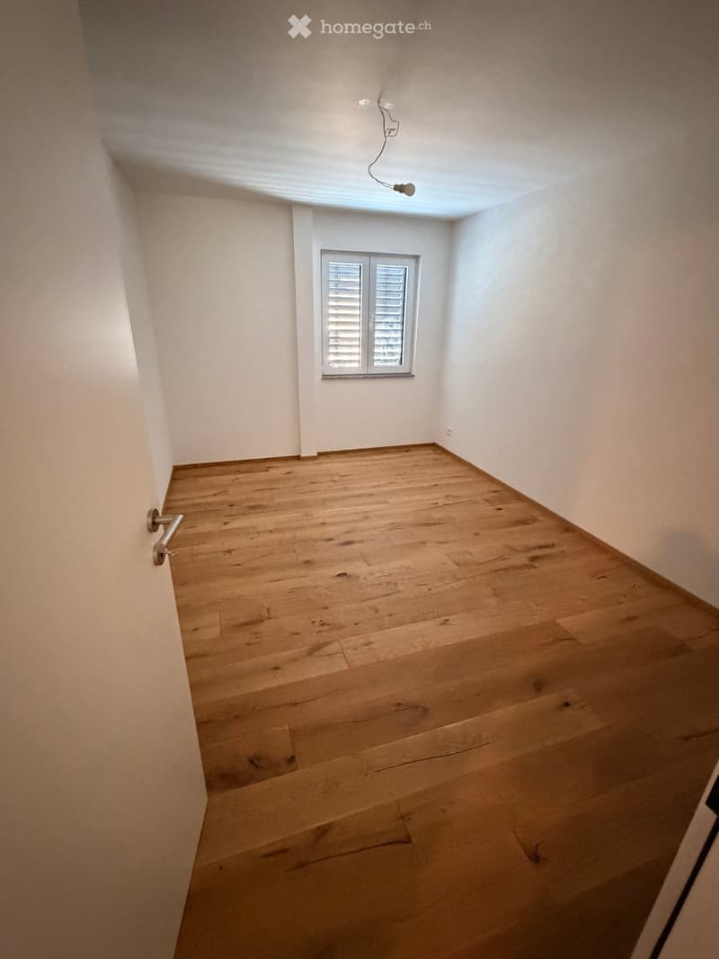 Empty room with wooden flooring, white walls, and a single window with blinds. No furniture or equipment is present.
