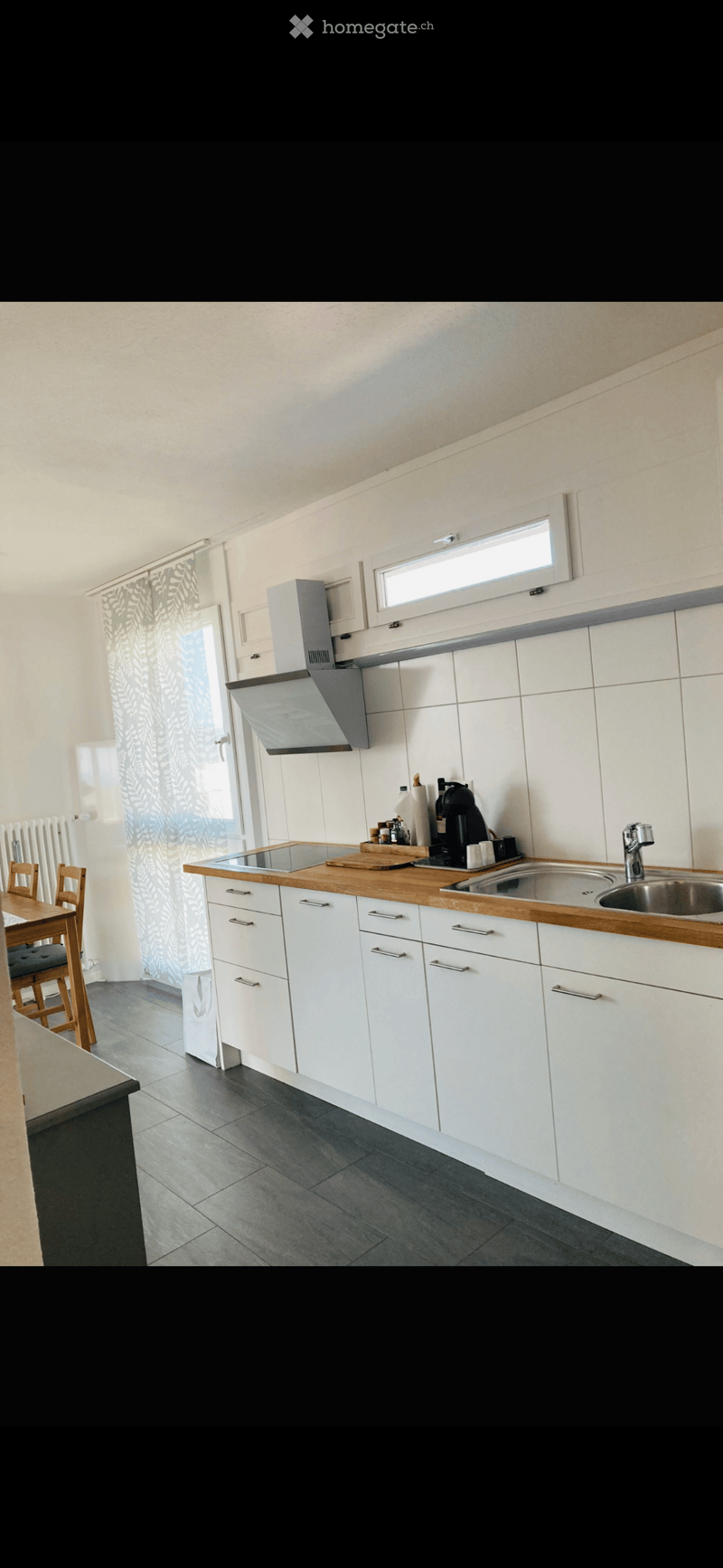 modern kitchen with white cabinets, wooden countertops, stainless steel sink, gas stove, extractor hood, white tiled walls, white ceiling