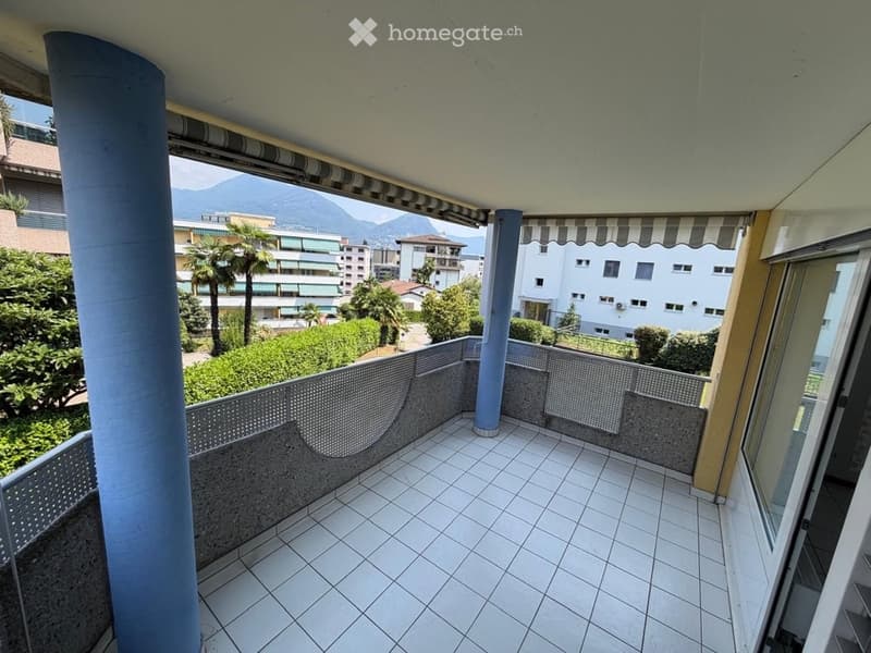 Balcony with tiled floor, metal railing, and scenic mountain view in the background.