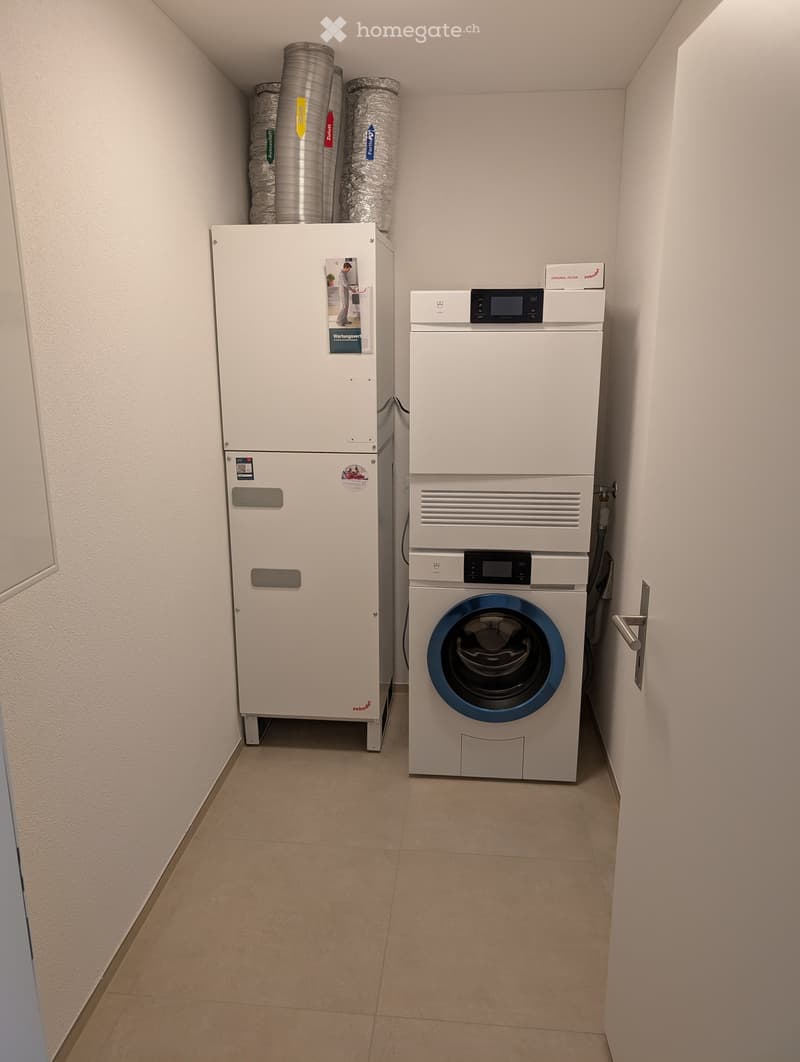 A small utility room with a washing machine and a dishwasher, both white, placed against the wall.