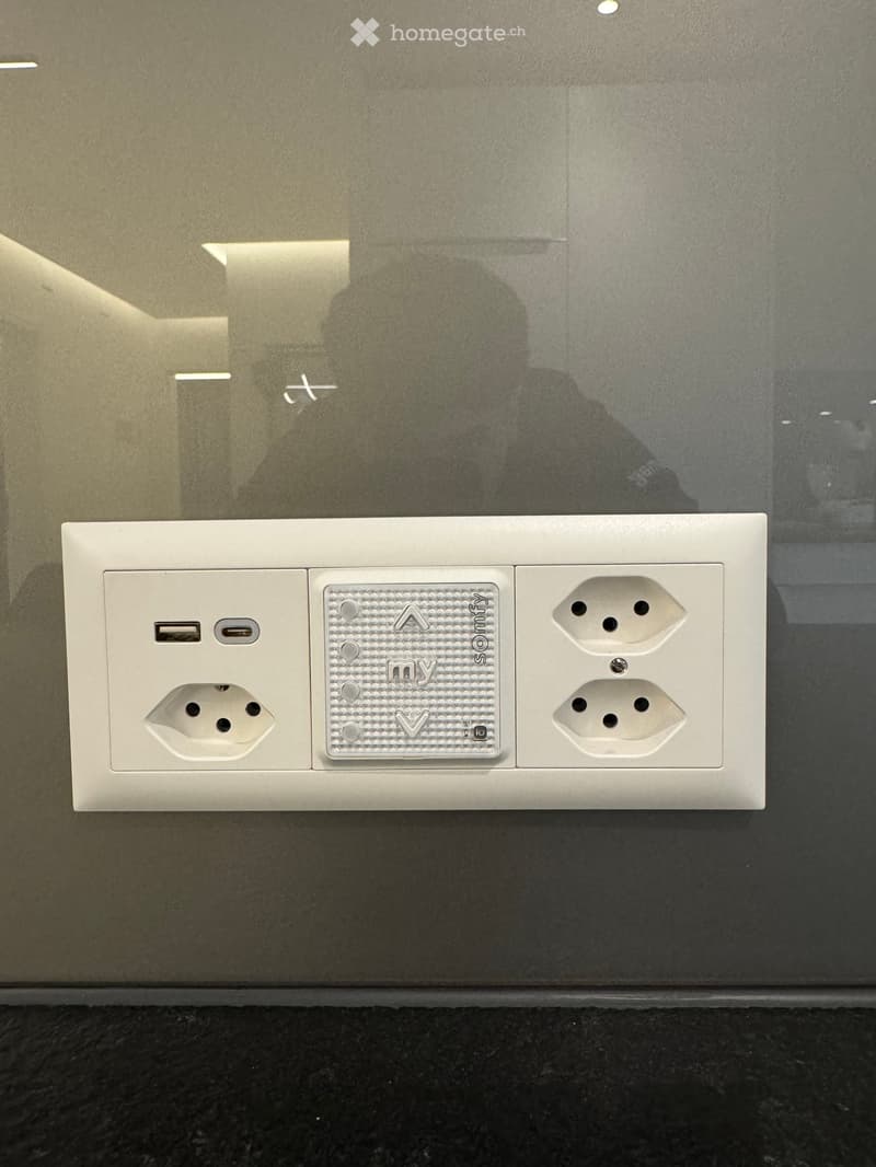 A modern wall outlet with multiple sockets and USB ports, featuring a sleek design and metallic accents.