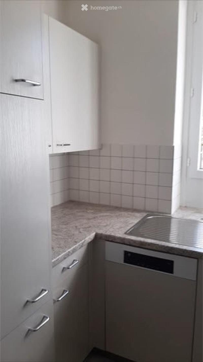 Modern kitchen with white cabinets, granite countertop, stainless steel sink, and built-in dishwasher.
