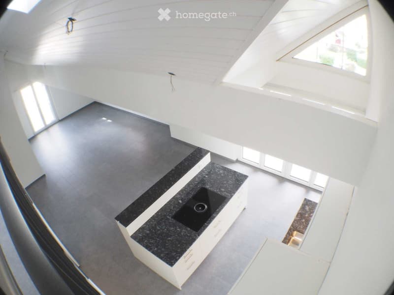 Open kitchen with island, black granite countertop, black induction hob, white cabinets, white ceiling, gray floor