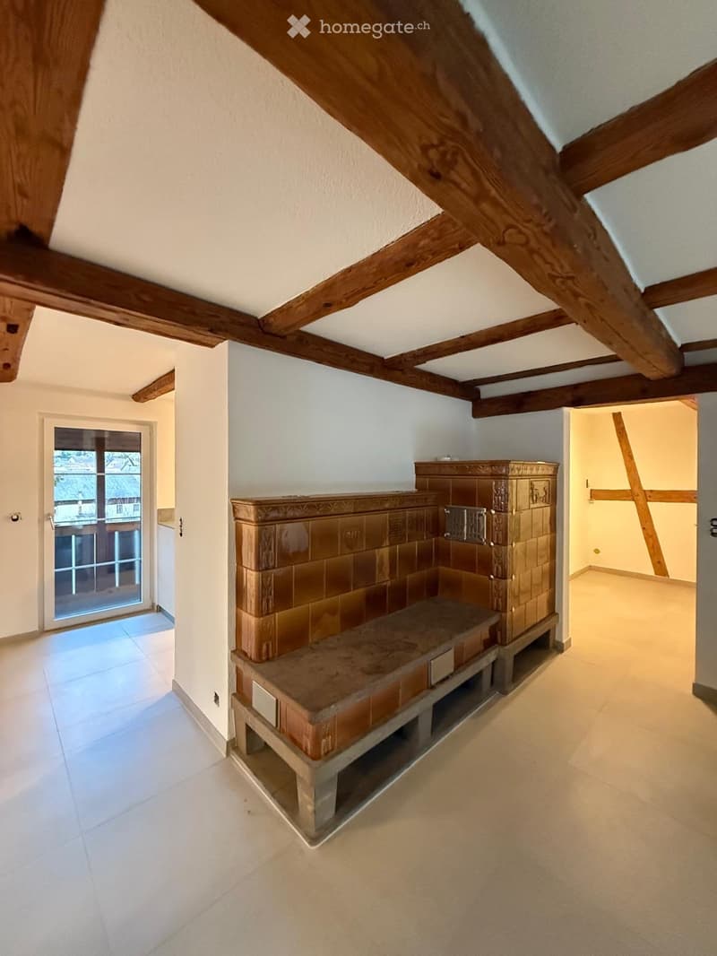 Hallway with exposed wooden beams, tiled floor, and a built-in bench with storage compartments.