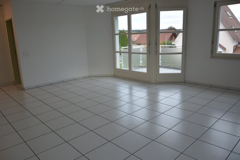 Empty room with white tiled floor, large glass sliding doors leading to a balcony, and a window on the right side.