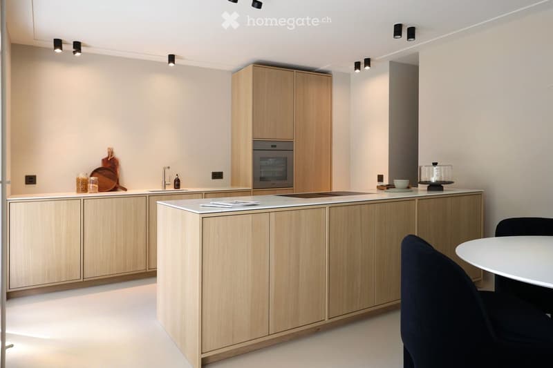 modern kitchen with wooden cabinets, marble countertop, built-in oven, sink with faucet, dining table and chairs