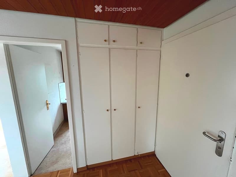 Empty room with white built-in wardrobes, wooden flooring, and a wooden ceiling. No furniture or personal items are present.