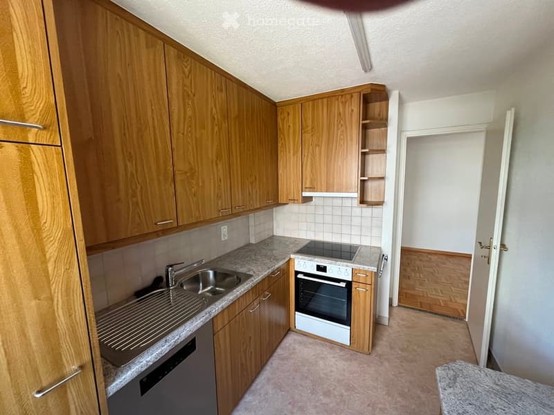 Modern kitchen with wooden cabinets, granite countertops, stainless steel sink, oven, and dishwasher.