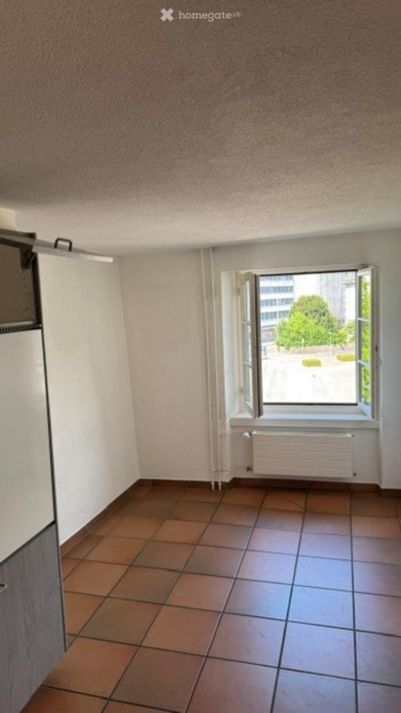 Empty room with tiled floor, white walls, and a window with open blinds. No furniture or equipment present.