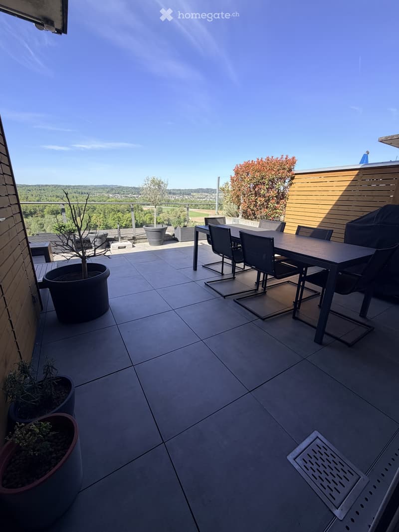 Balcony with tiled floor, outdoor dining set, potted plants, and scenic view.