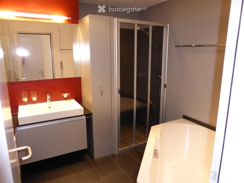 Modern bathroom with a white sink, bathtub, glass-enclosed shower, and mirrored cabinet.