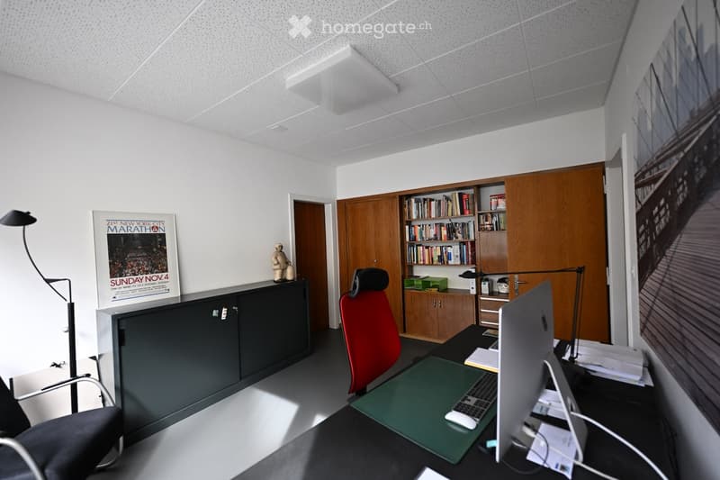 desk with computer and chair, framed picture, cabinet with books, black chair
