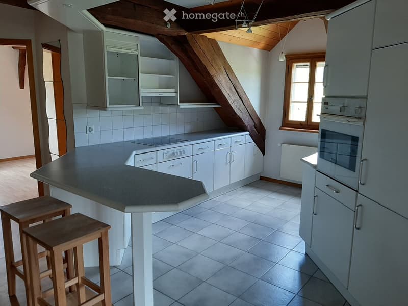 Modern kitchen with white cabinets, stainless steel appliances, and a central island with wooden stools.
