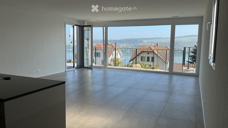 Empty room with large sliding glass doors opening to a scenic view, tiled floor, and modern design.