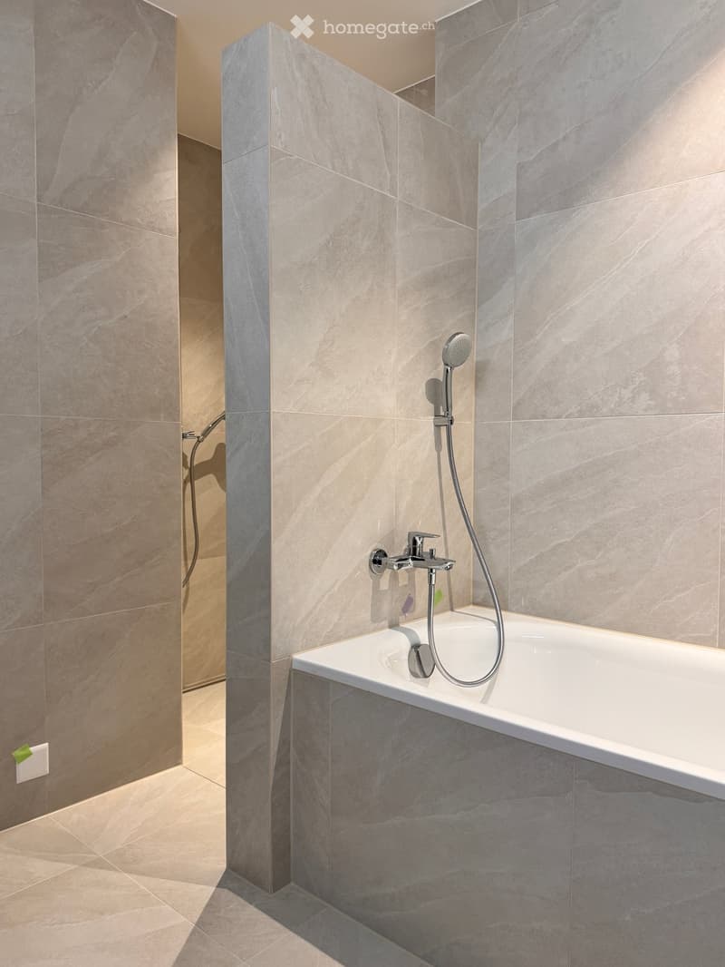 Bathroom. Bathroom with marble tiles, bathtub, and shower fixtures.