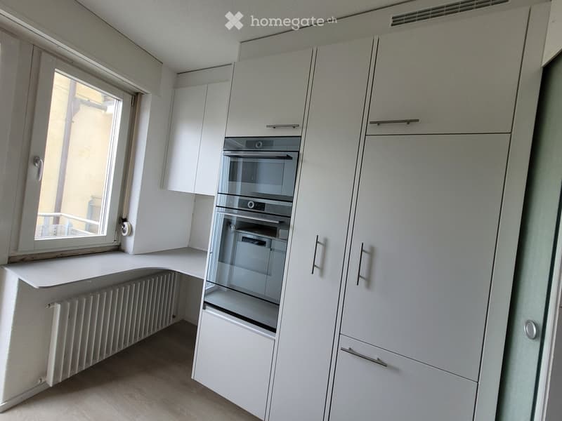 Kitchen. Modern kitchen with white cabinets, built-in oven, and a window providing natural light.
