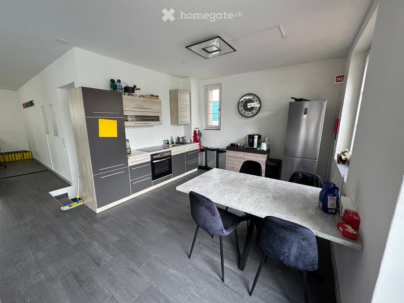 modern kitchen with wooden cabinets, granite countertop, stainless steel appliances, and a dining area with a marble table