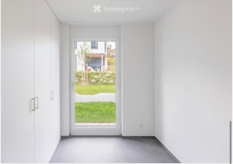 empty room with a door opening to a grassy lawn