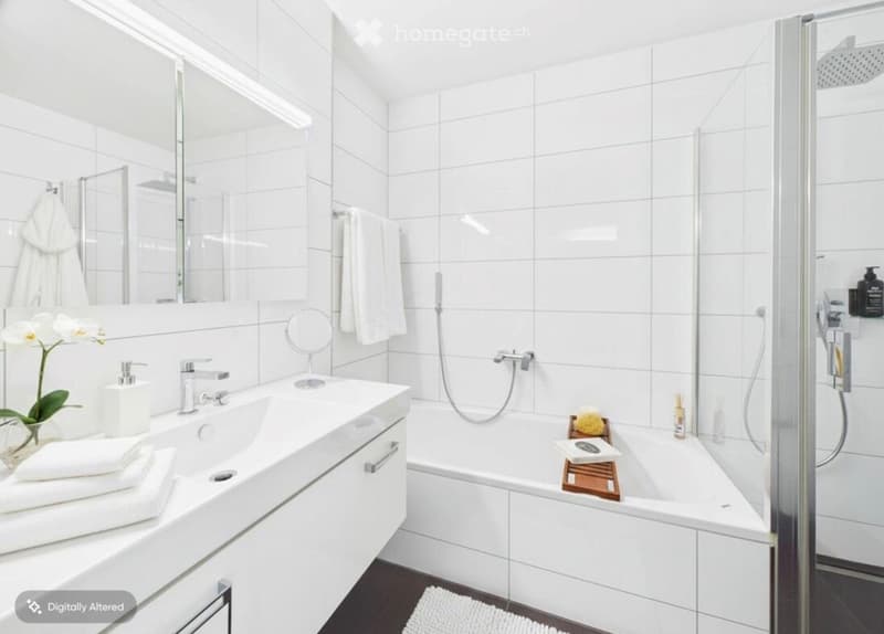 Modern bathroom with white tiles, a large sink with a mirror, a bathtub, and a glass-enclosed shower area. Includes towels, a flower arrangement, and a bathtub tray with toiletries.
