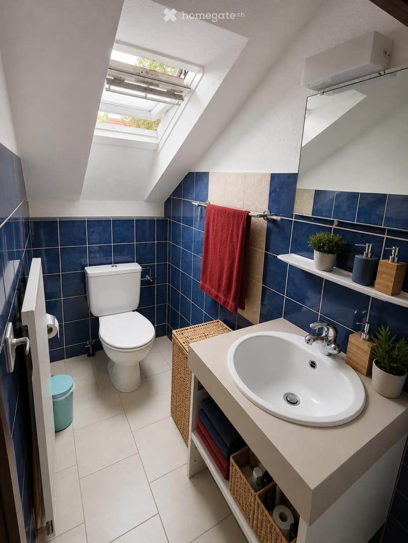 Cozy attic bathroom with blue tiles, white fixtures, skylight window, and a small sink vanity with a wicker basket underneath.