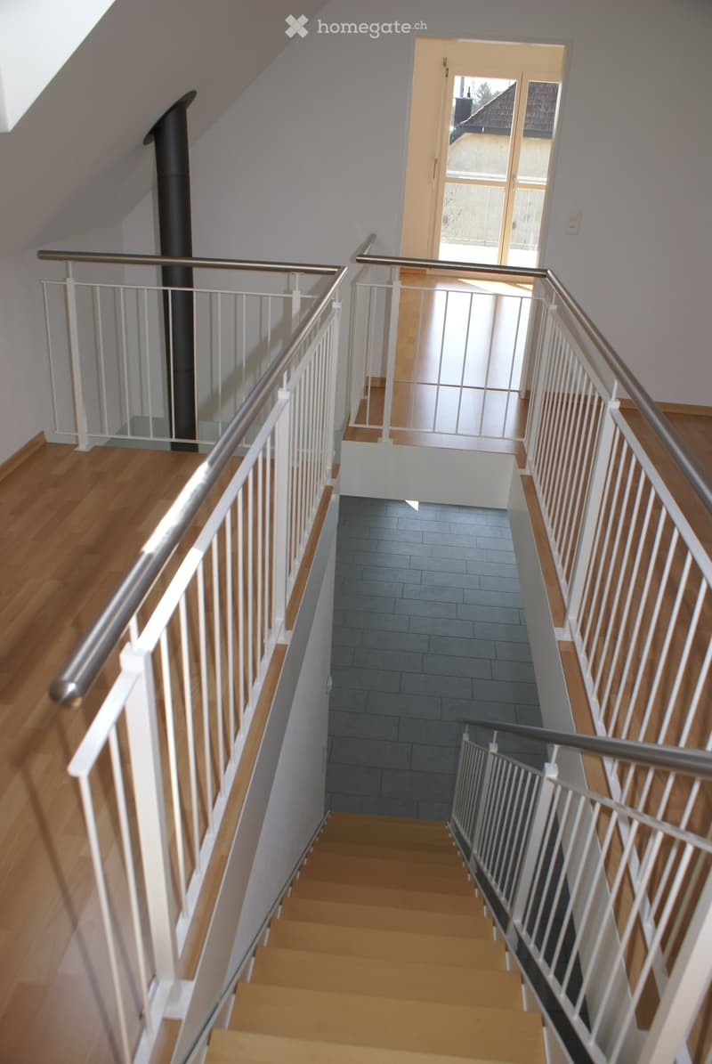 Modern staircase with wooden steps, white railings, and a glass door leading to an outdoor area.
