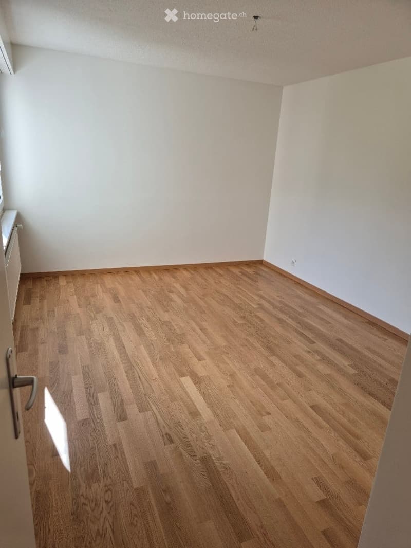 Completely empty room with bare white walls and wooden flooring. No furniture or equipment.