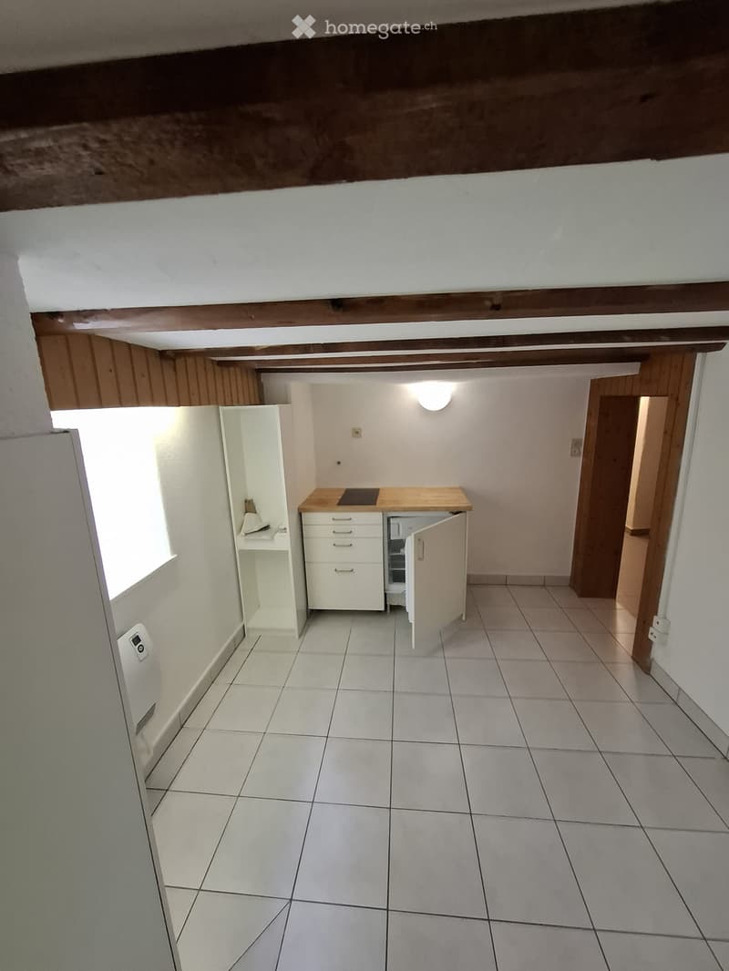 Kitchen with appliances and cabinets, ceramic tiled floor, wooden beams, large window