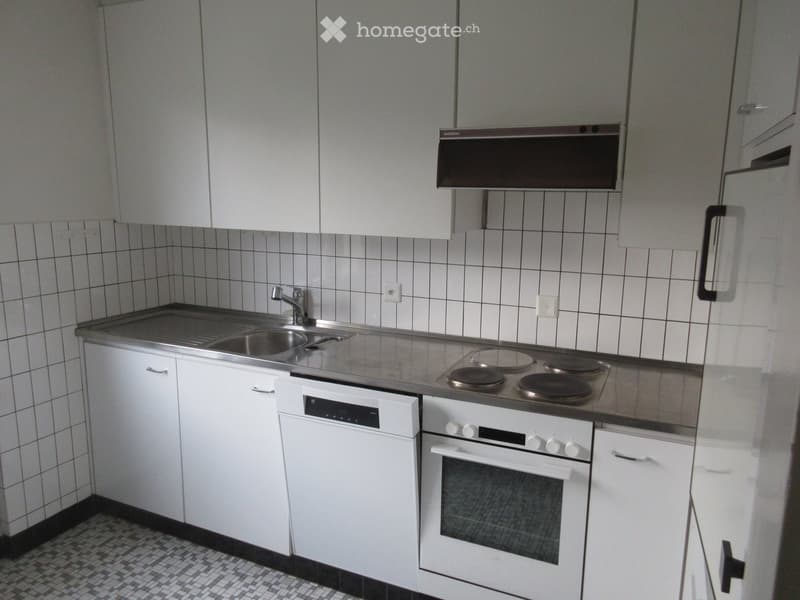 Compact kitchen with white cabinets, a sink, electric stove, oven, and dishwasher.