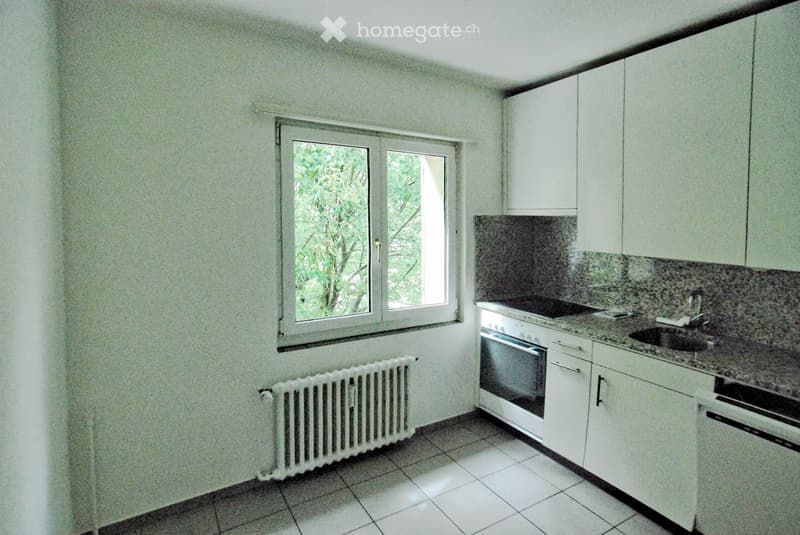 kitchen with white tiles, window, white cabinets, integrated oven and dishwasher