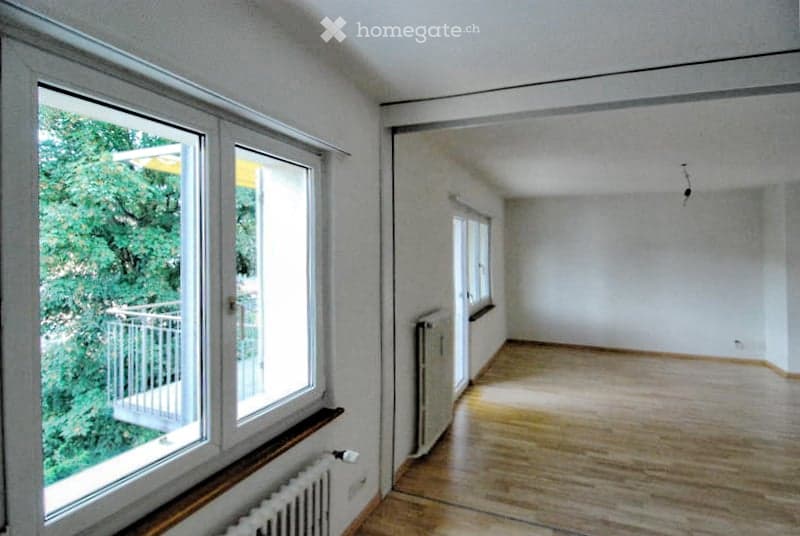 large windows, balcony, wooden floor, white walls, radiators