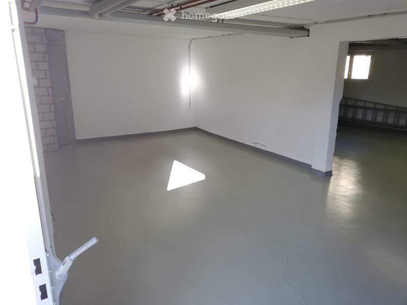 empty garage, grey floor, white walls, ceiling lamp