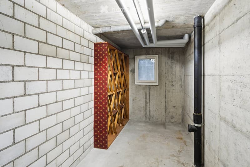 brick wall, wooden shelving, a window, pipework