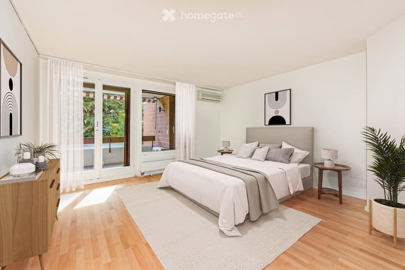 Modern bedroom with a large bed, nightstands, lamps, and a view of a balcony. The room features light-colored walls, wooden flooring, and contemporary decor including a large mirror and artwork.
